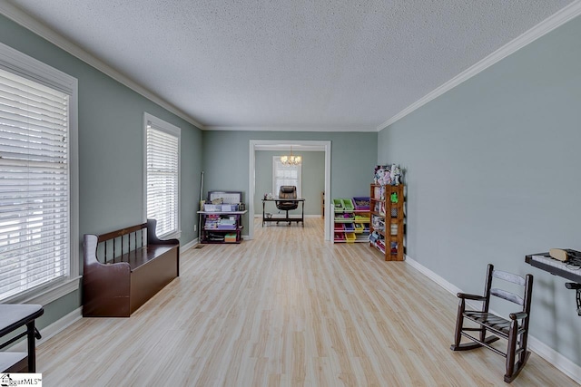 sitting room with a textured ceiling, a notable chandelier, wood finished floors, baseboards, and ornamental molding