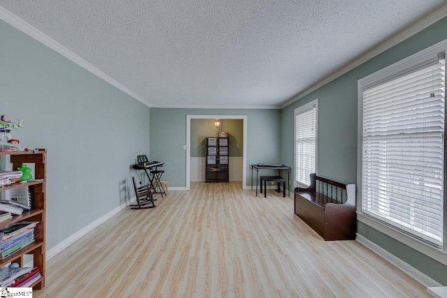 sitting room with ornamental molding, a textured ceiling, baseboards, and wood finished floors