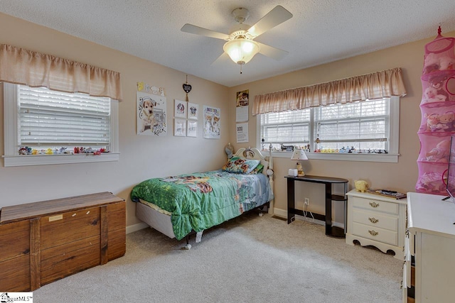 bedroom with a ceiling fan, light carpet, a textured ceiling, and baseboards