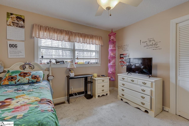 bedroom with light carpet, ceiling fan, a textured ceiling, and baseboards