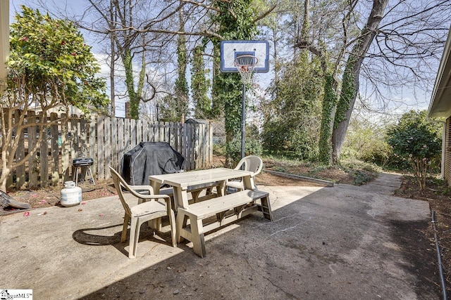 view of patio with outdoor dining space, a grill, and fence