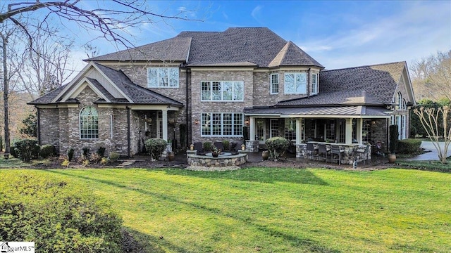 back of property with a yard, brick siding, and roof with shingles