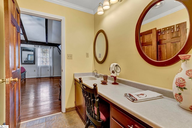 bathroom featuring baseboards, ornamental molding, and vanity