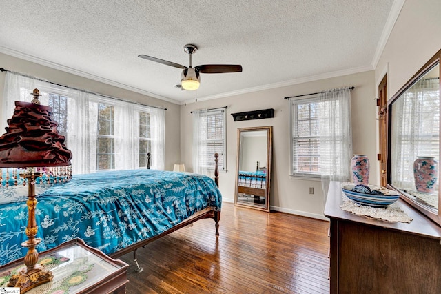 bedroom with baseboards, a textured ceiling, wood-type flooring, and crown molding