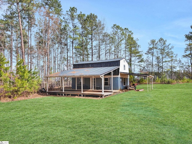 back of house featuring metal roof and a yard