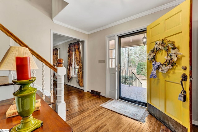 entryway with ornamental molding, stairway, baseboards, and wood finished floors