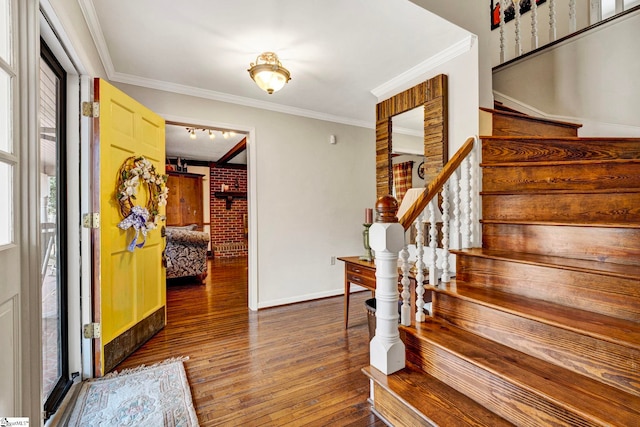 foyer entrance featuring hardwood / wood-style floors, stairs, baseboards, and crown molding