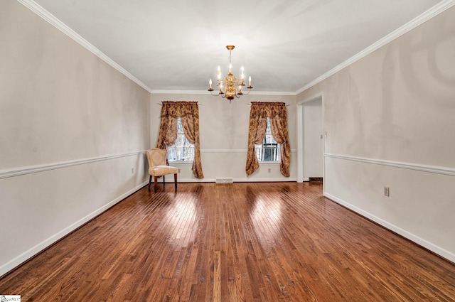 empty room with a chandelier, baseboards, crown molding, and hardwood / wood-style floors