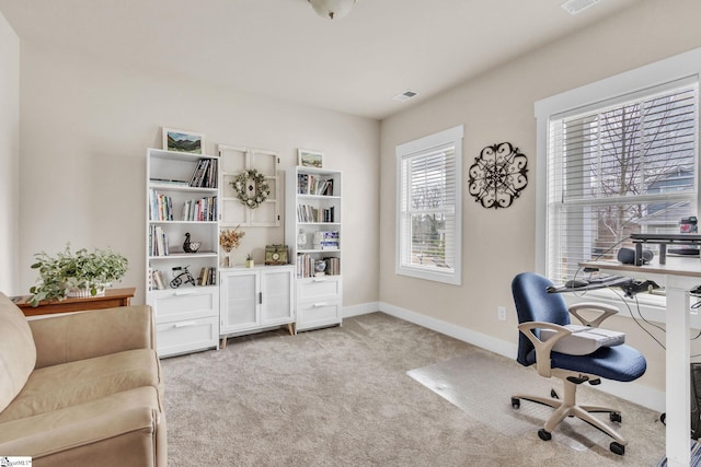 office featuring light carpet, visible vents, and baseboards