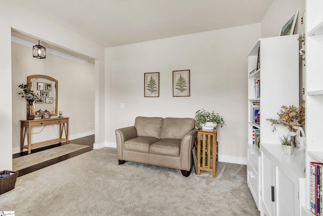 carpeted living room featuring baseboards