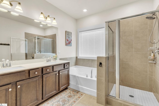 full bath featuring tile patterned flooring, a shower stall, a garden tub, and a sink