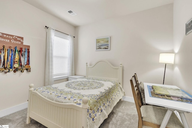 bedroom featuring visible vents, light carpet, and baseboards