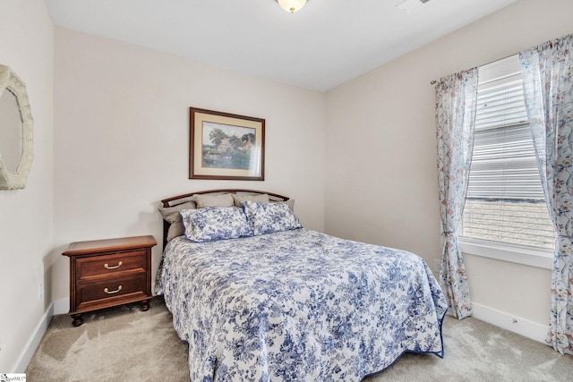 bedroom featuring baseboards, multiple windows, and light colored carpet