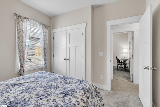 bedroom featuring baseboards, a closet, and light colored carpet