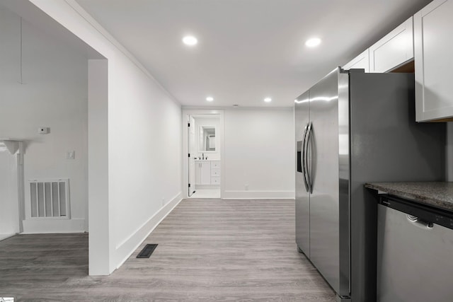 kitchen featuring appliances with stainless steel finishes, visible vents, and light wood-style floors