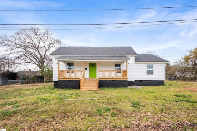 bungalow-style home with a shingled roof, a porch, crawl space, a front lawn, and a detached carport