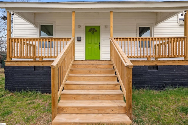 entrance to property featuring covered porch and crawl space