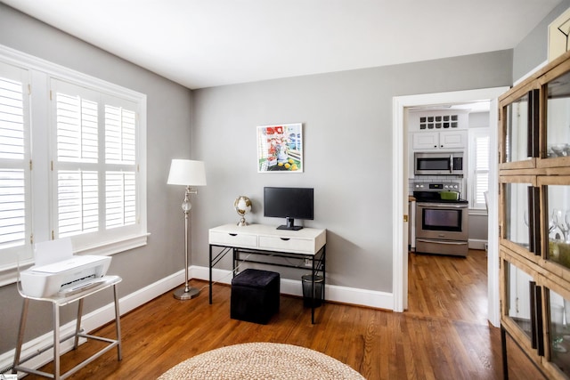 home office featuring baseboards and wood finished floors