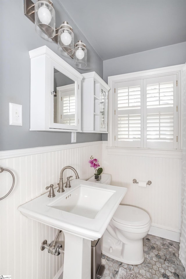 bathroom with a wainscoted wall and toilet