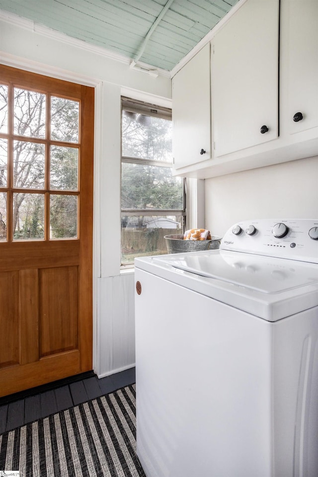 laundry area with wainscoting, cabinet space, and washer / dryer