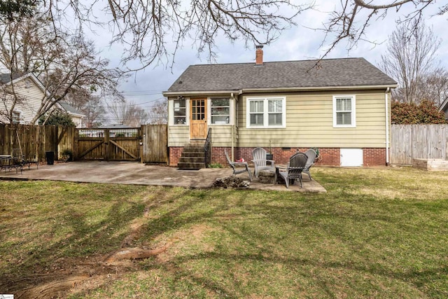 back of house featuring a gate, a patio, a lawn, and fence