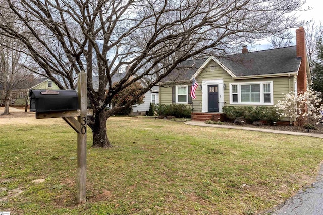 view of front of property featuring a shingled roof, a chimney, and a front yard