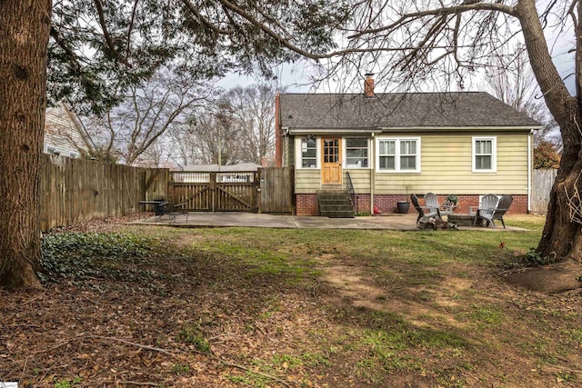 back of property featuring entry steps, an outdoor fire pit, fence, a gate, and a chimney