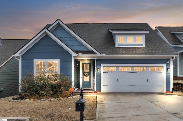 view of front facade with a garage, driveway, and a shingled roof