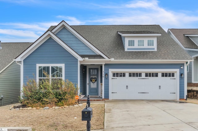 view of front of property featuring driveway, a garage, and roof with shingles