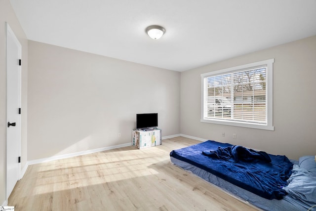 bedroom with baseboards and wood finished floors