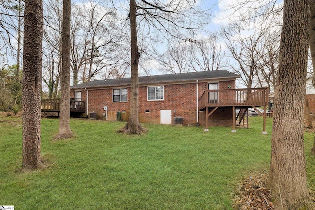 rear view of house featuring a yard, brick siding, crawl space, and a wooden deck