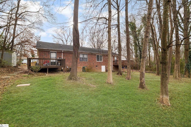 back of house featuring crawl space, a yard, a deck, and brick siding