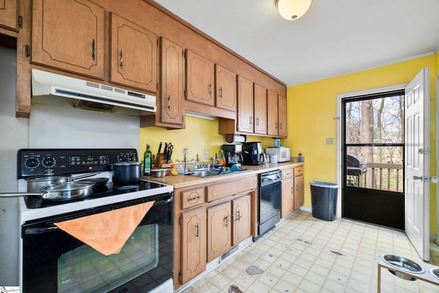 kitchen featuring light floors, light countertops, a sink, under cabinet range hood, and black appliances