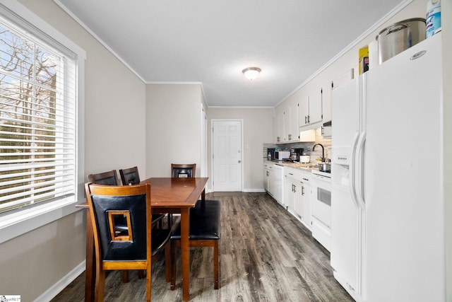 dining space with dark wood-style floors, ornamental molding, and baseboards