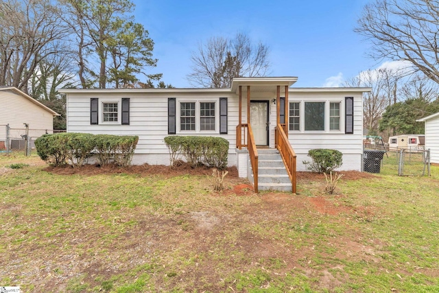 view of front of home featuring a gate, fence, and a front lawn