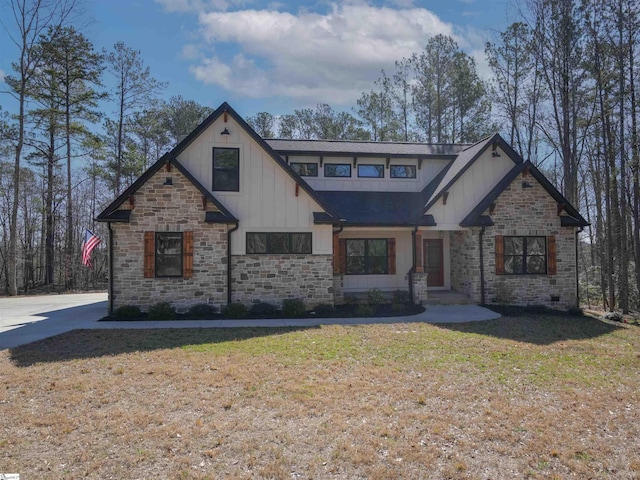 view of front facade with board and batten siding and a front yard