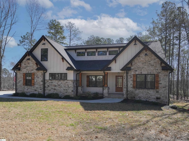 view of front of property featuring a front lawn, board and batten siding, and roof with shingles