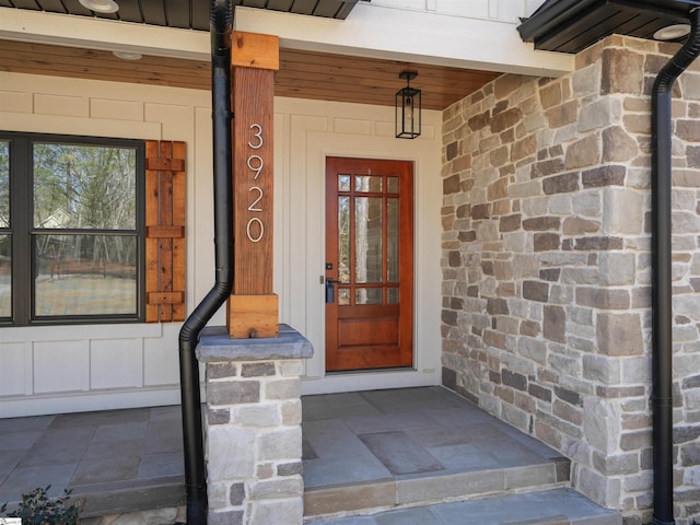 entrance to property with stone siding and board and batten siding