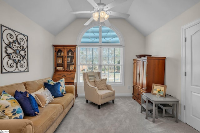 living room featuring vaulted ceiling, baseboards, a ceiling fan, and light colored carpet