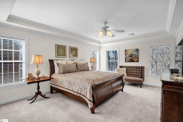 bedroom featuring a tray ceiling, visible vents, and light carpet