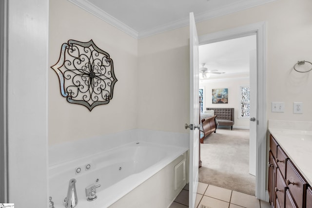 ensuite bathroom with ornamental molding, ceiling fan, vanity, a jetted tub, and tile patterned floors