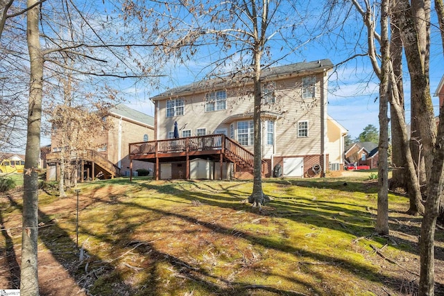 rear view of house with a yard, stairway, and a wooden deck