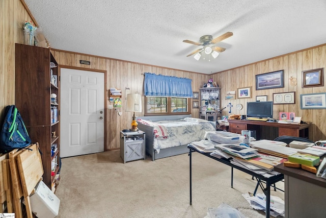 bedroom featuring a textured ceiling, wood walls, carpet, and crown molding