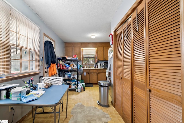 kitchen featuring a sink, brown cabinets, and a textured ceiling