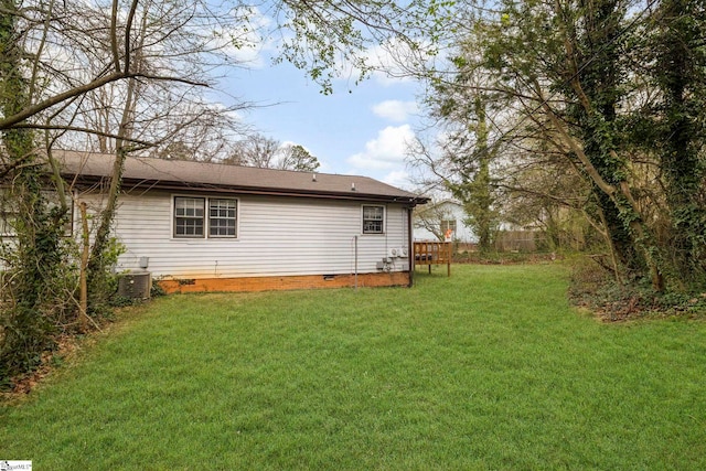 rear view of house featuring crawl space, fence, a lawn, and central air condition unit