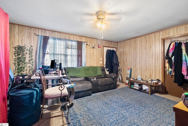 living room featuring a ceiling fan, carpet floors, and wooden walls