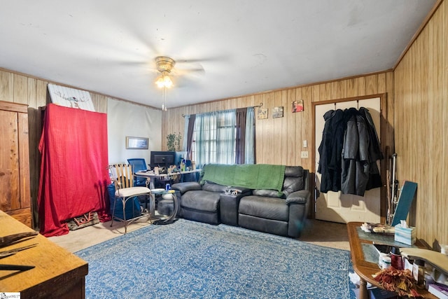 living area with wood walls and a ceiling fan