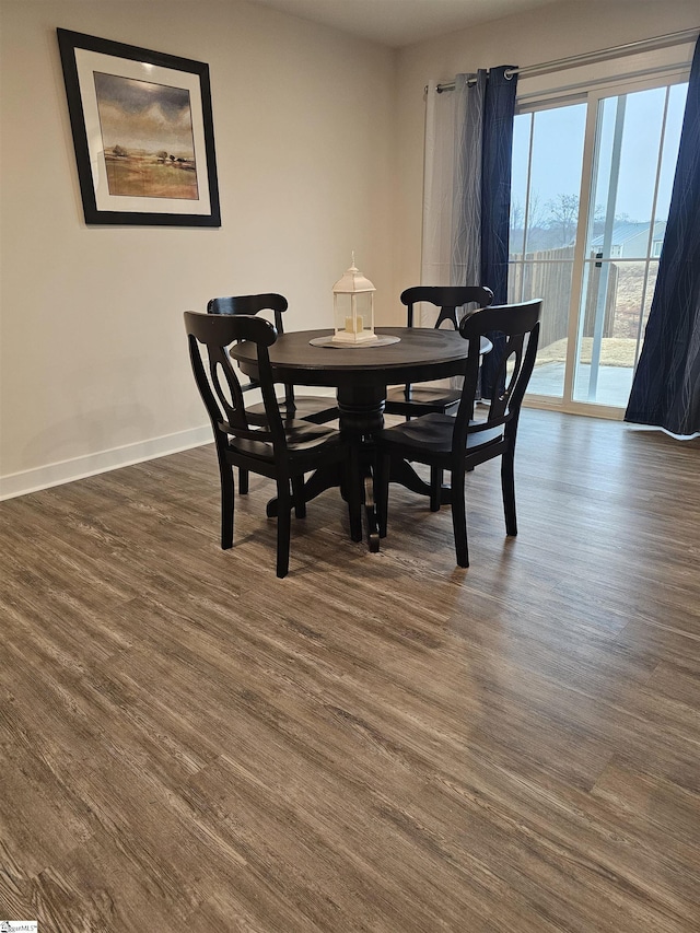 dining area with baseboards and dark wood finished floors