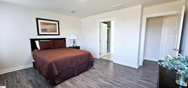 bedroom with visible vents, baseboards, and wood finished floors