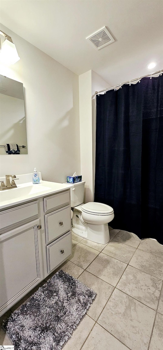 bathroom featuring visible vents, vanity, toilet, and tile patterned floors